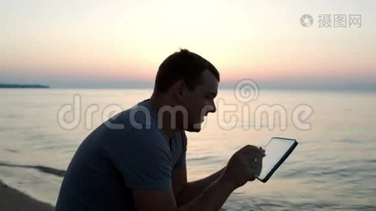 在海滩上使用平板电脑的人视频