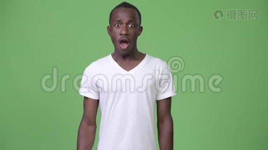年轻快乐的非洲男人在绿色的背景下举起拳头视频