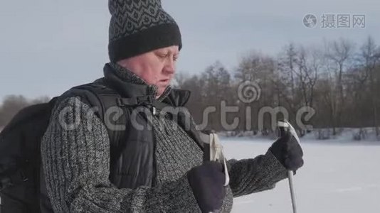 一位老年妇女在冬季森林里用木棍做北欧人的散步。 健康的生活方式观念。 成熟成熟视频