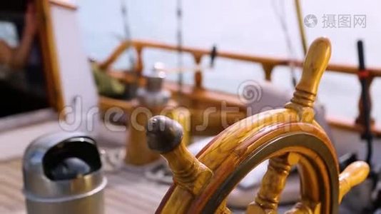 在阳光明媚的一天，一艘木制古董帆船的方向盘和甲板在海洋中航行，展示了木制部件和视频
