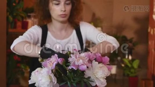 花店，花店布置现代花束，年轻英俊的花店在花店做花束视频