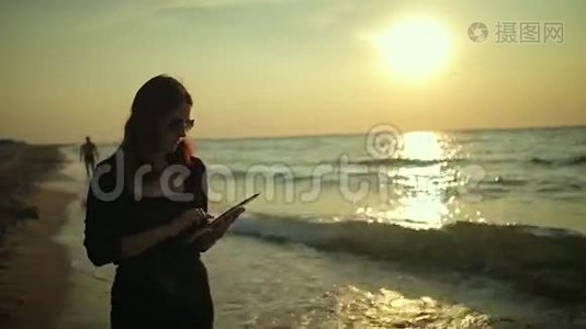女人在海边使用平板电脑视频