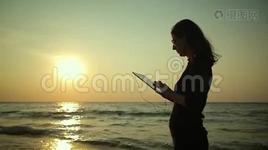 女人在海边使用平板电脑视频