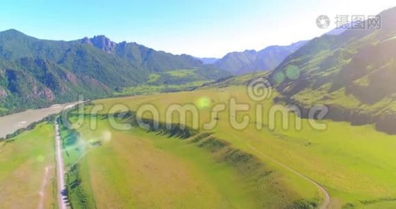 阳光明媚的夏季早晨，空中乡村山路和草地。 沥青公路和河流..视频