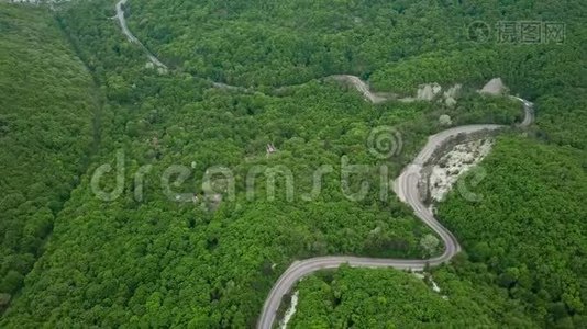 上景。 从无人驾驶飞机上俯瞰。 山林中的路很美，有许多树，公路上蜿蜒曲折视频