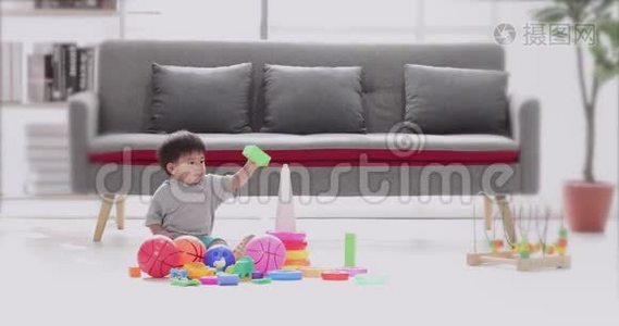 亚洲男孩坐在地板上玩玩具。视频