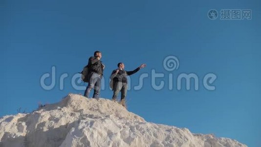 两个人游客徒步探险登山者爬山。 慢动作视频。 徒步旅行者登上顶峰赢得胜利视频