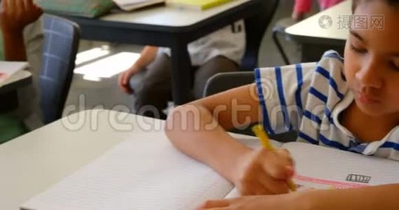 混合种族的小学生在4k教室的课桌上学习视频