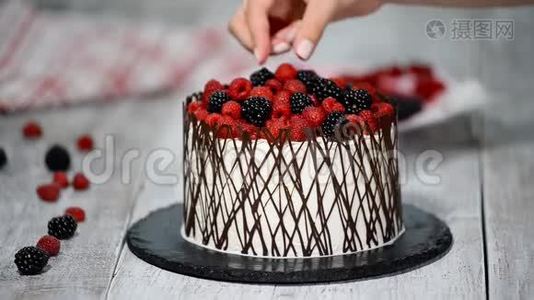 糕点厨师用浆果装饰蛋糕。视频