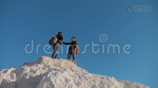 两个人游客徒步探险登山者爬山。 慢动作视频。 徒步旅行者登上顶峰赢得胜利视频