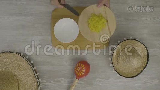 用刀子把食物放进盘子里。 桌子上有两顶墨西哥帽子，马拉卡，是Instagram的抽象物视频