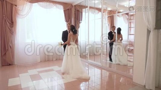 年轻一对相爱的夫妻穿着婚纱在室内视频