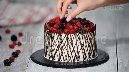 糕点厨师用浆果装饰蛋糕。视频