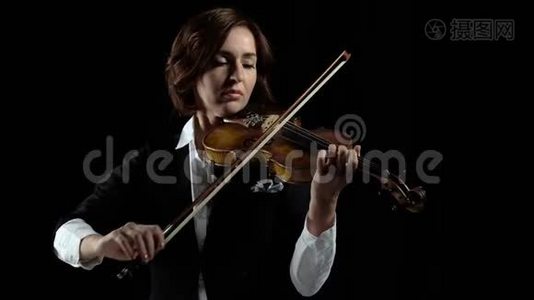 在房间里演奏小提琴的女孩。 黑色背景视频