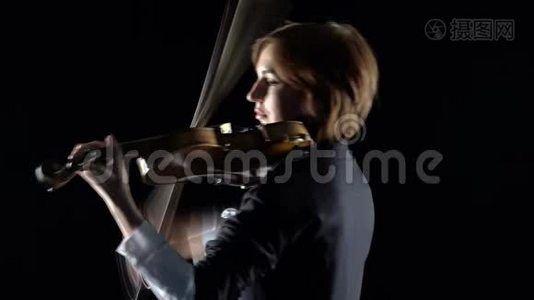 小提琴家在一个黑人工作室里用小提琴作曲. 黑色背景视频