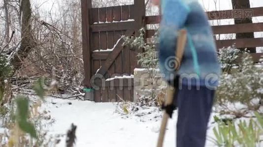 冬天打扫房子附近的雪。 幼儿清理铲雪覆盖轨道..视频