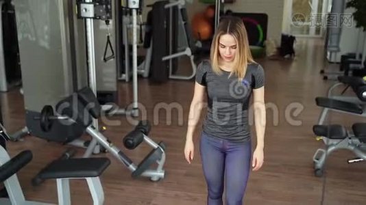 年轻迷人的女人在健身房做力量训练。视频