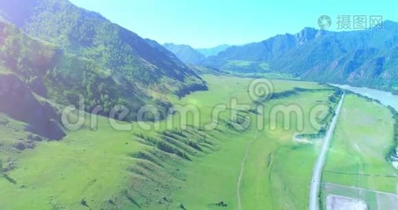 阳光明媚的夏季早晨，空中乡村山路和草地。 沥青公路和河流..视频