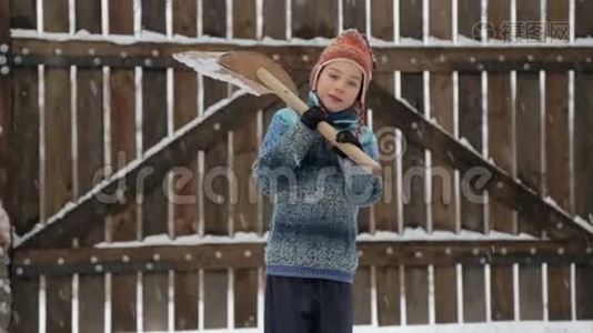 男孩在房子附近摘下雪铲。 冬天打扫房子附近的雪。视频