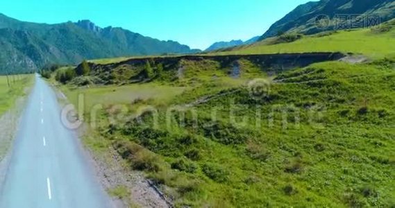 阳光明媚的夏季早晨，空中乡村山路和草地。 沥青公路和河流..视频