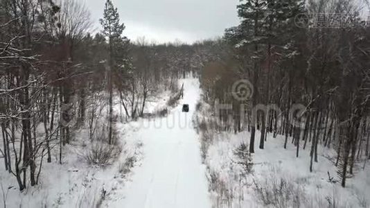 从空中观看越野车6x6，在冬季森林的积雪道路上行驶，后景视频