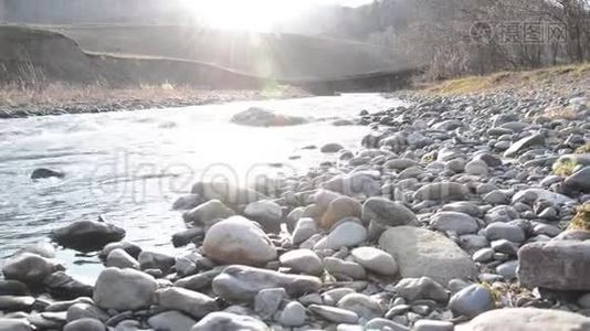 多利滑块拍摄了在森林附近的一条山河里飞溅的水。 潮湿的岩石和阳光。 水平稳定视频