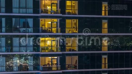 在玻璃摩天大楼的时间推移，夜晚的公寓窗户会发光视频