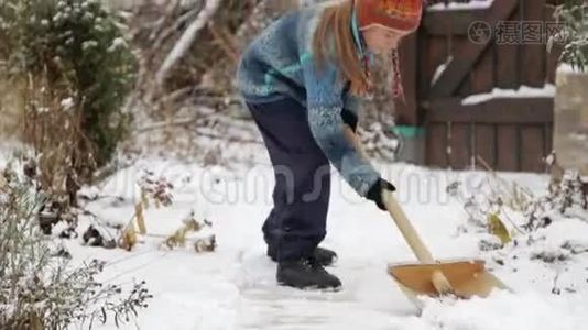 男孩在房子附近摘下雪铲。 冬天打扫房子附近的雪。视频