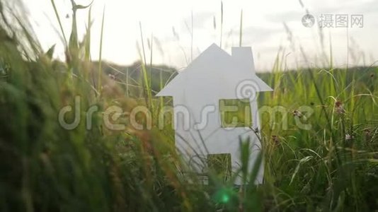 建设幸福家庭建设住宅理念生活方式.. 纸屋矗立在大自然的绿草中。 符号符号视频