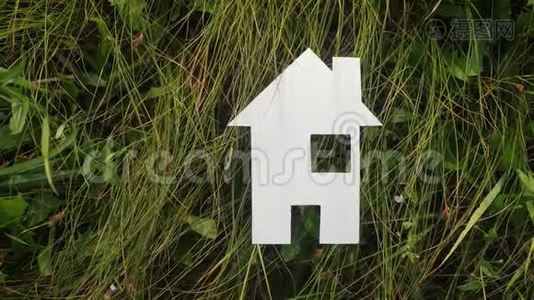 幸福家庭建房理念生活方式.. 纸屋矗立在大自然的绿草中。 象征生命生态视频