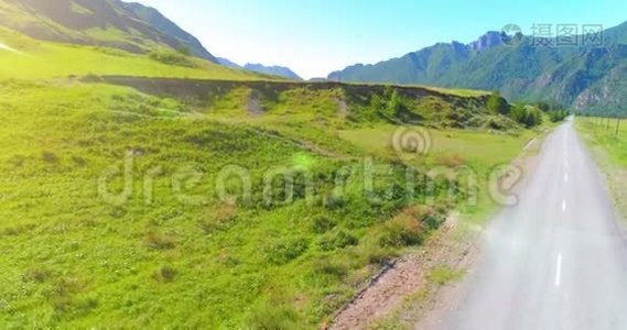 阳光明媚的夏季早晨，空中乡村山路和草地。 沥青公路和河流..视频