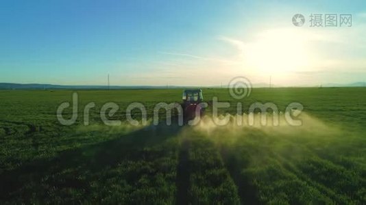 农用拖拉机耕田喷洒的空中日出景观。视频