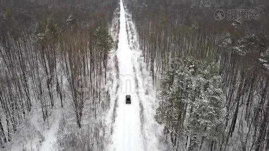 从空中观看越野车6x6，在冬季森林的积雪道路上行驶，后景视频