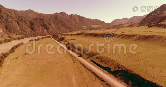 阳光明媚的夏季早晨，空中乡村山路和草地。 沥青公路和河流..视频