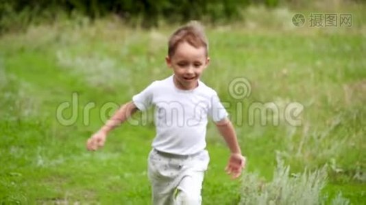 快乐的孩子在绿草上缓慢地奔跑。视频