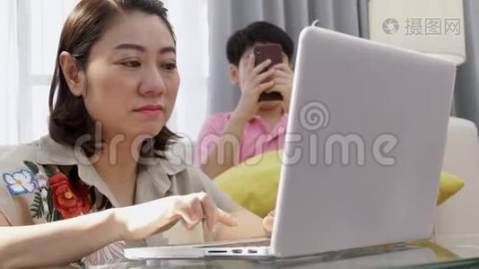 亚洲母子在笔记本电脑上微笑着看着。视频