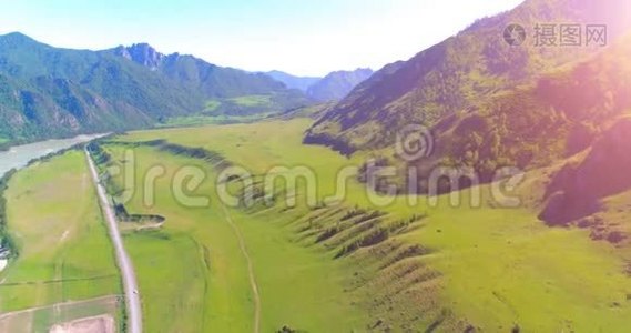 阳光明媚的夏季早晨，空中乡村山路和草地。 沥青公路和河流..视频