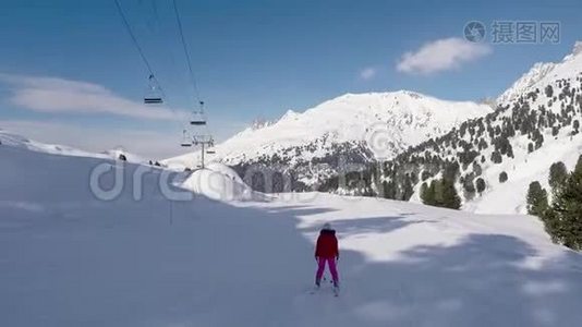 在晴朗的一天，滑雪者在冬季山区的滑雪坡上滑雪视频