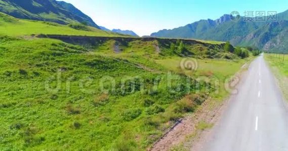 阳光明媚的夏季早晨，空中乡村山路和草地。 沥青公路和河流..视频