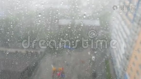 在暴风雨的一天里，城市的雨滴落在窗户上，背景下的城市天际线视频
