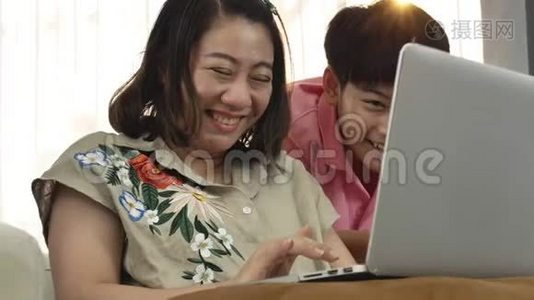 亚洲母子在笔记本电脑上微笑着看着。视频