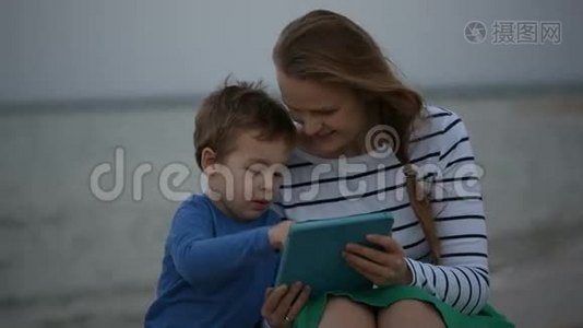 母亲和儿子坐在海边视频