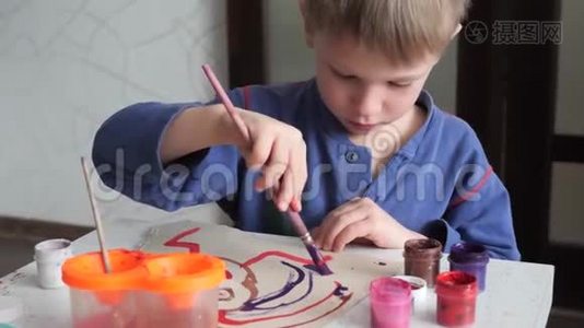 小男孩热情地在纸上用水彩作画。视频