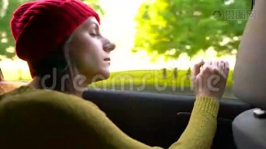 阳光明媚的一天，幸福的年轻女子坐在副驾驶座上看着窗外视频