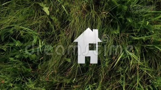 幸福生活方式家庭建设住宅理念.. 纸房子矗立在大自然的绿草中。 生命象征生态视频