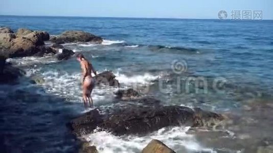 岩石海滩上美丽的年轻女士视频