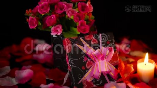 装饰情人节礼物盒，蜡烛燃烧和玫瑰花瓣镜头视频
