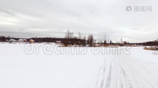 冬天，在雪覆盖的湖面上，汽车在结冰的轨道上行驶。 空中观景。 冬季雪地赛道上的赛车视频