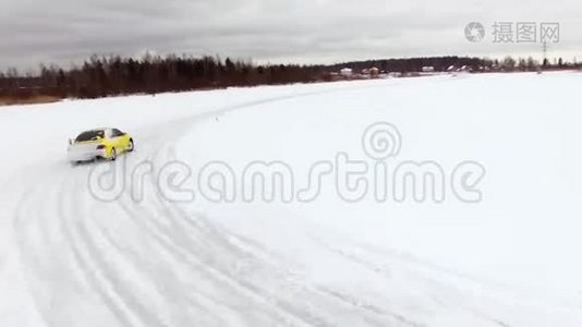 冬天，在雪覆盖的湖面上，汽车在结冰的轨道上行驶。 空中观景。 冬季雪地赛道上的赛车视频