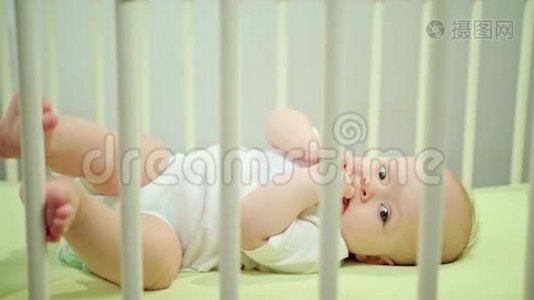 婴儿躺在婴儿床上吃它的手指视频